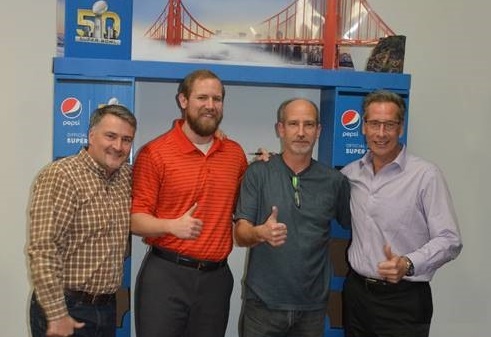 people standing in front of Pepsi Super Bowl display